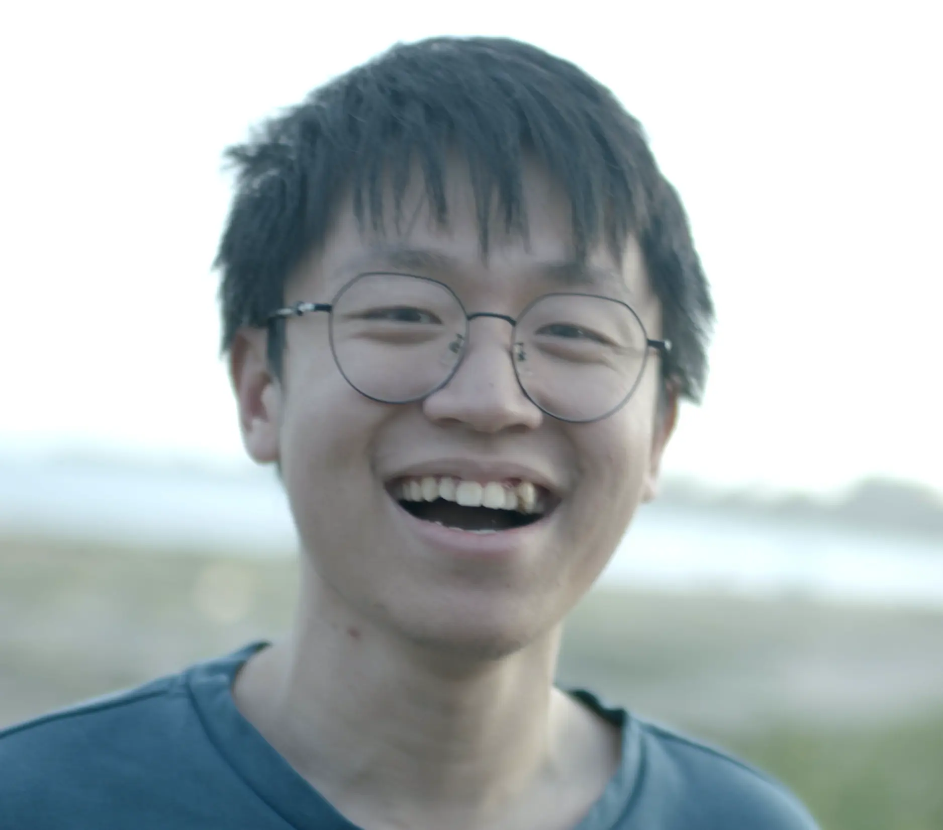 Portrait of Tianle Yu, smiling, outdoors by the water